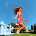 Woman skipping with a pink TORRAS NeoCable outdoors, showing its flexibility