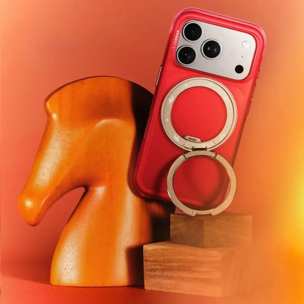 TORRAS Year of Horse red iPhone 17 case with magnetic Q & O3 Air Stand, by wooden horse.
