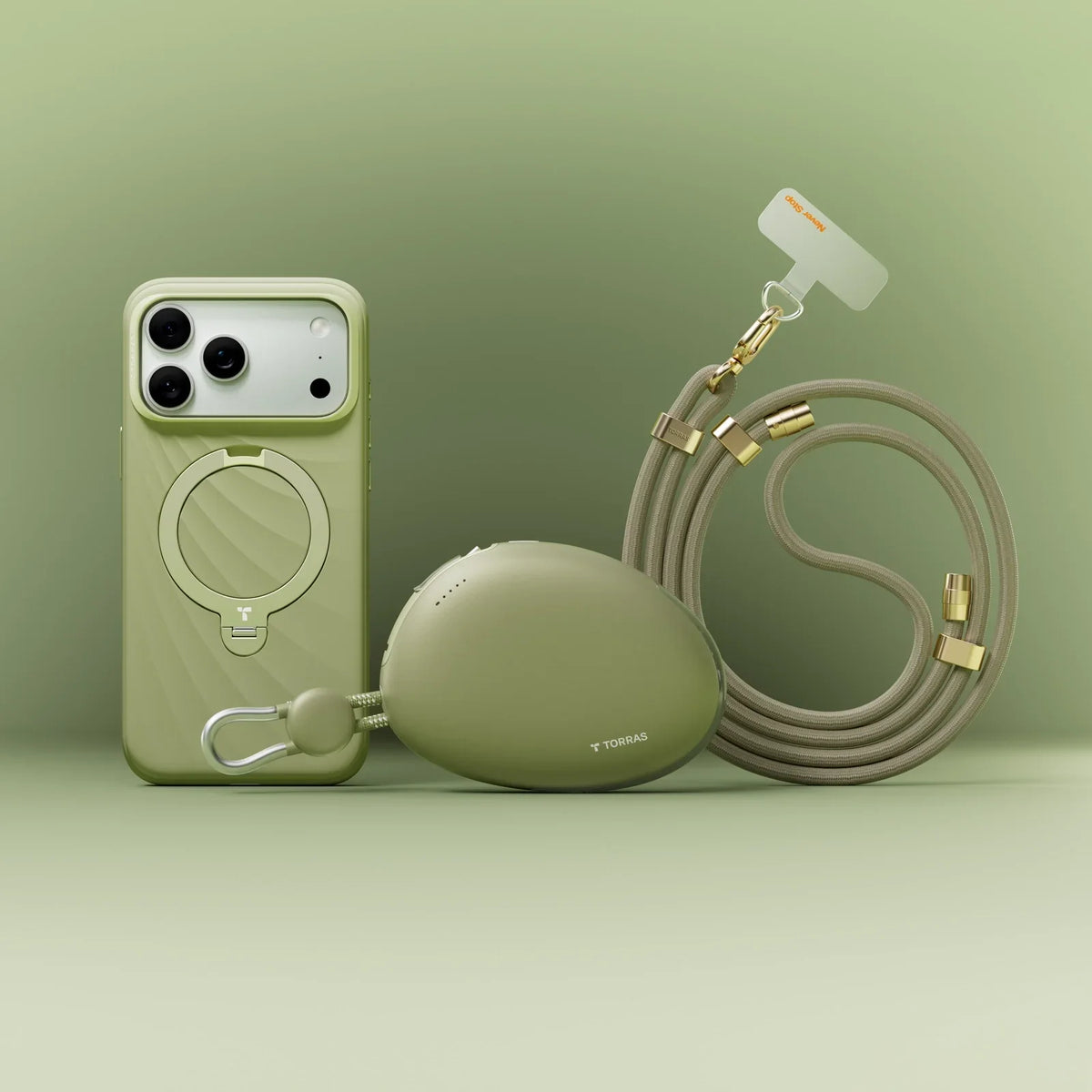 Sage green TORRAS Ostand Q3 Silicone Wind Limited iPhone 17 Pro Max case with magnetic stand, pebble charger, and lanyard.