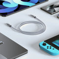 TORRAS Iceflow low-temp silver braided USB-C fast charging cable, coiled with tech devices.