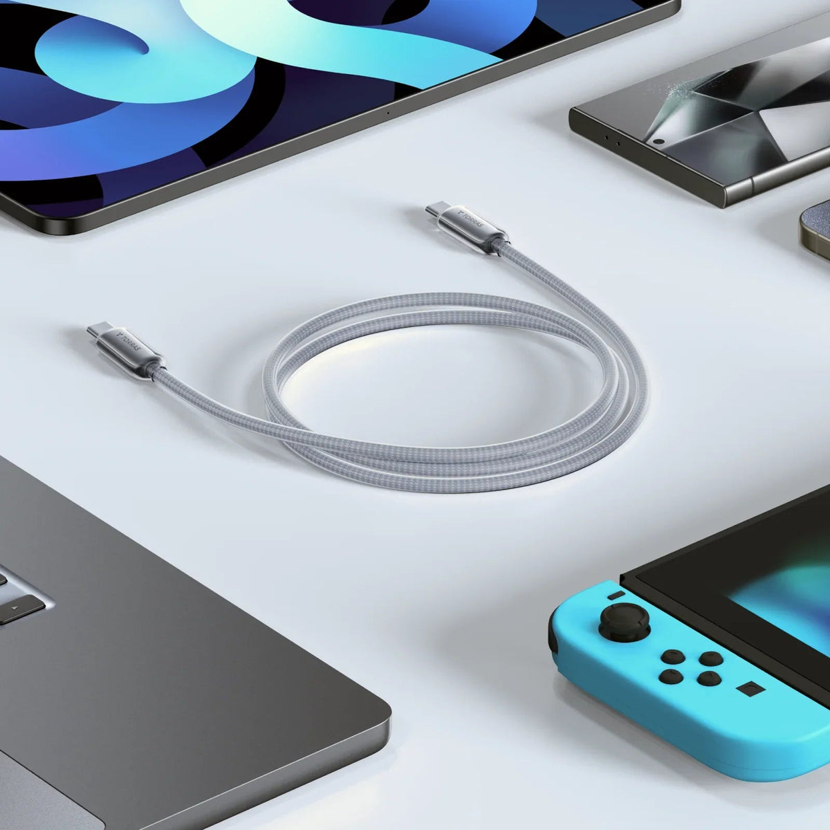 TORRAS Iceflow low-temp silver braided USB-C fast charging cable, coiled with tech devices.