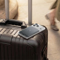 TORRAS MiniMag Pro 5k mAh magnetic power bank attached to iPhone on suitcase