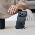 TORRAS Ostand Q3 Spin case for iPhone 17 in dark grey with magnetic ring stand extended.