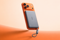 One Space Grey PB20B attached to an orange phone, with its built-in cable loop