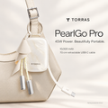 PearlGo Pro Pearl White power bank clipped to a cream handbag, with feather finish and retractable USB-C cable; styling accessories shown