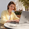 PearlGo Pro charging a USB-C laptop on a sunlit cafe table