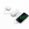 PearlGo power bank charging earbuds and a phone with the USB-C lanyard cable routed through the top ring and cable tie